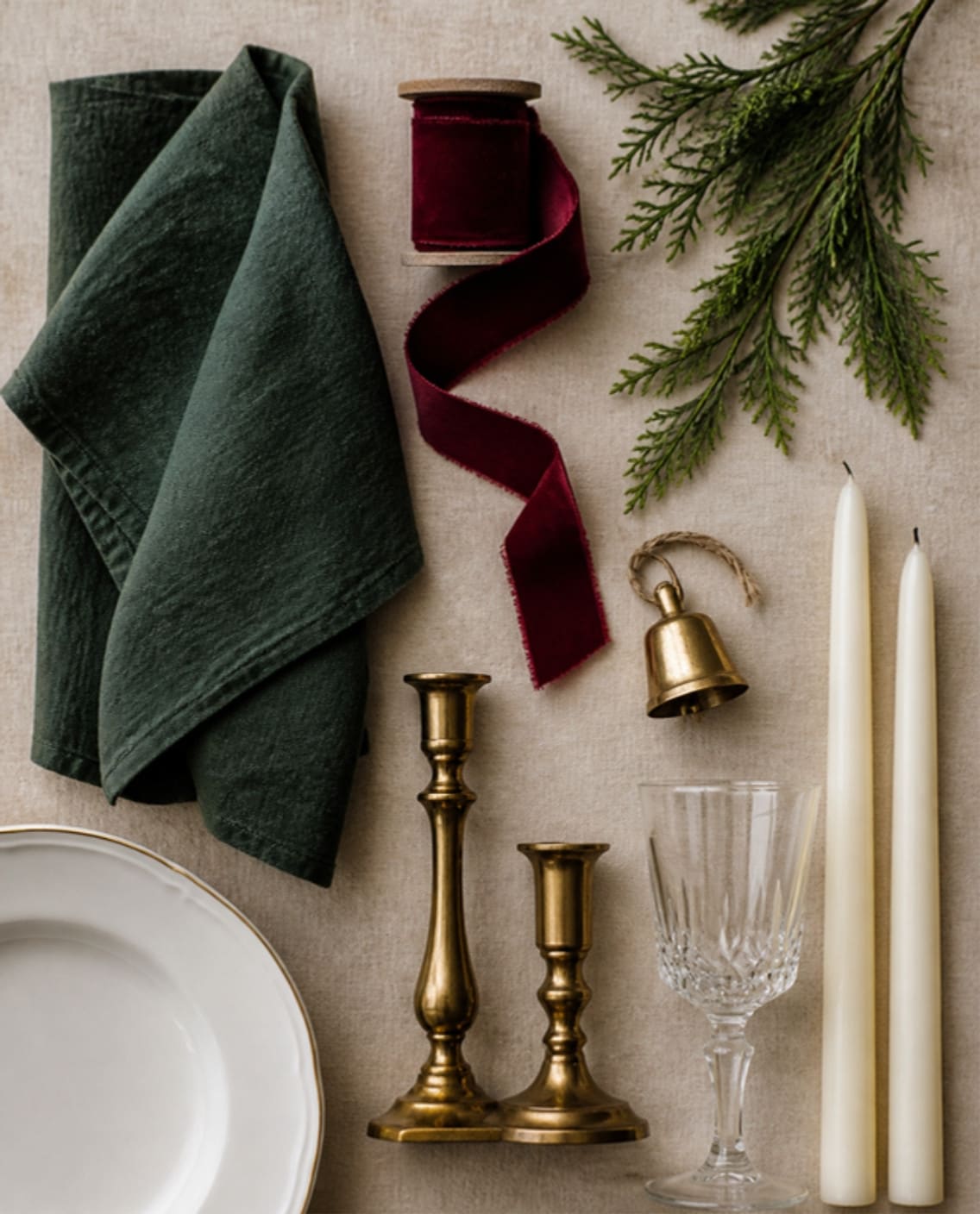 Mood board: Mood board of the materials: green linen, cranberry velvet ribbon, cedar, a brass bell, brass candlesticks and ivory tapers.